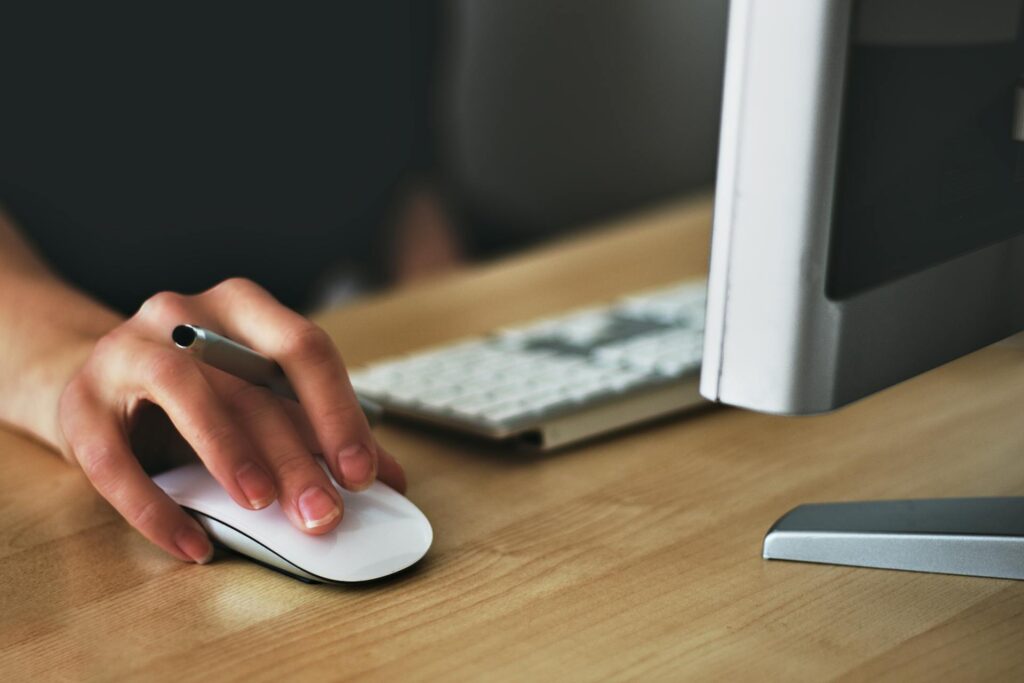 Person using a mouse to navigate their computer.